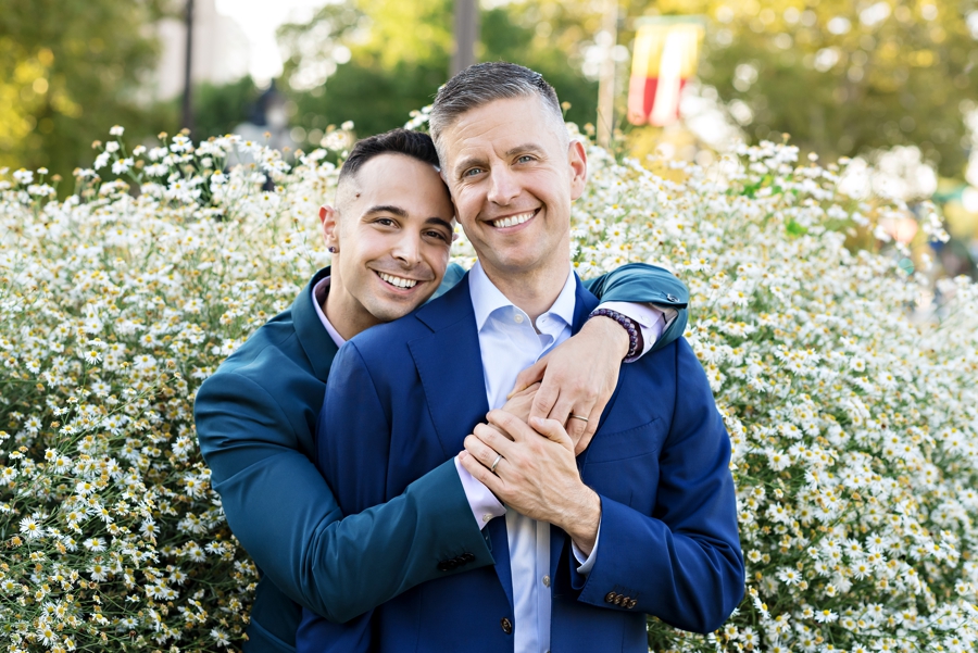Two men hold each other and smile in their same sex Philadelphia engagement session.